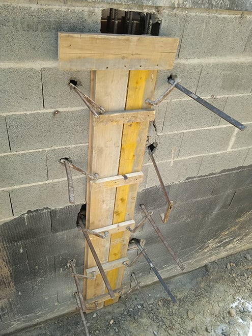 Photo montrant un mur percé avec des planches de bois dessus